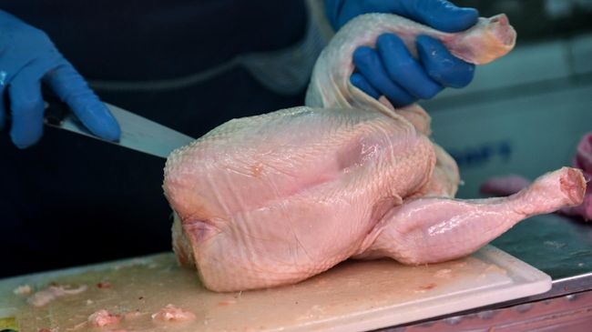 Продавец разделывает курицу на рынке в Симферополе