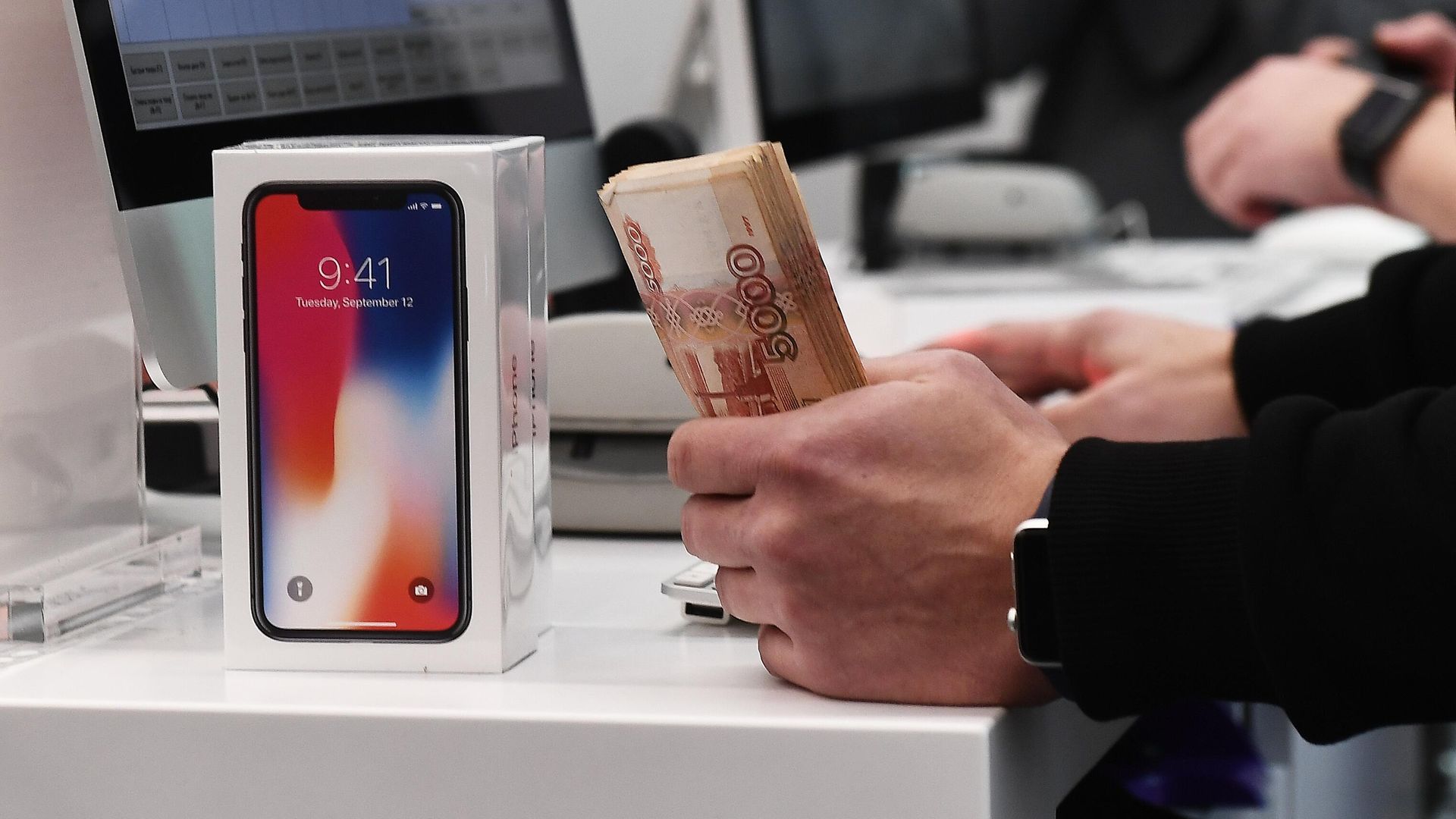 Продавец за прилавком пробивает покупку смартфона Продавец за прилавком пробивает покупку смартфона - РИА Новости, 1920, 31.01.2022