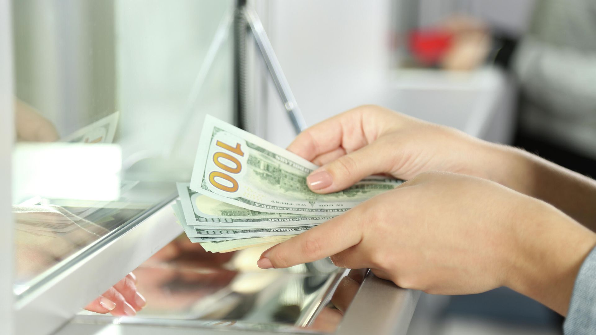 Женщина пересчитывает долларовые купюры в банке Женщина пересчитывает долларовые купюры в банке - РИА Новости, 1920, 22.03.2023