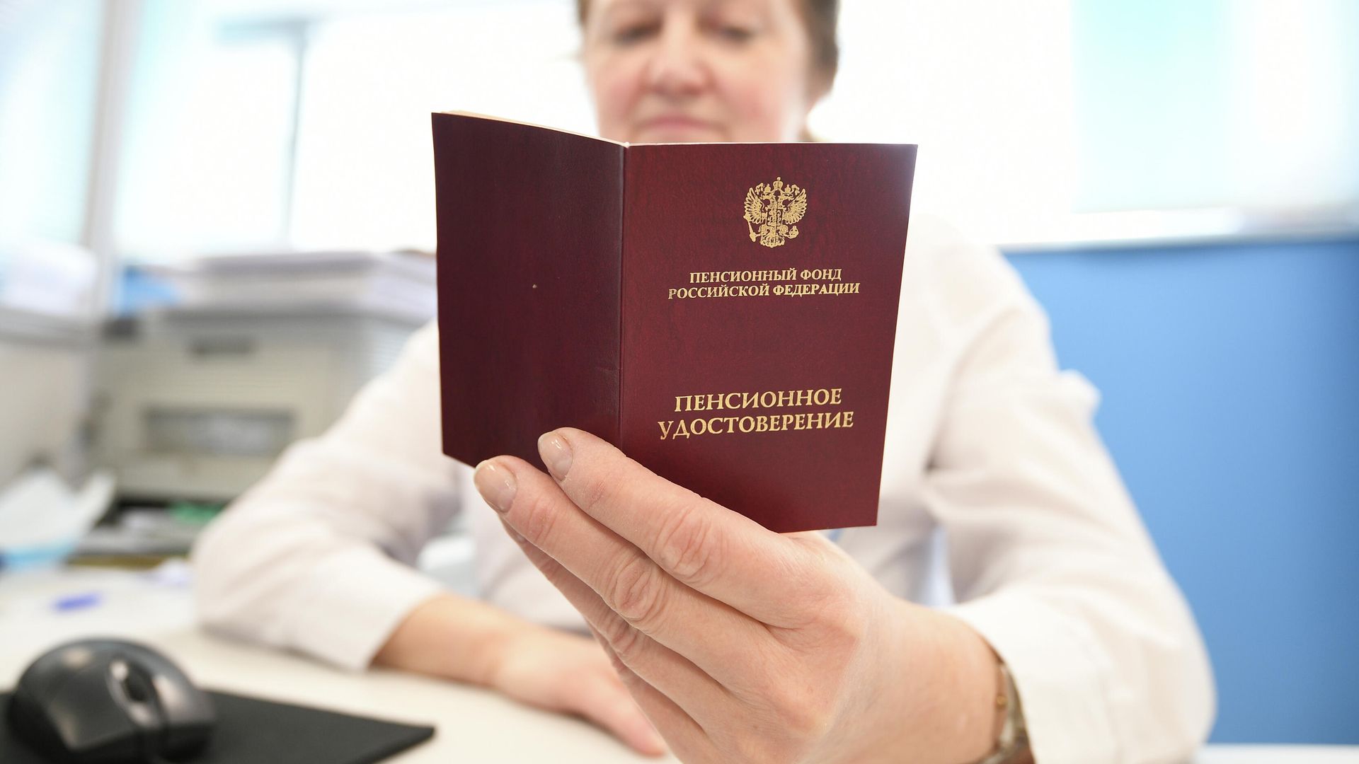 Сотрудник ПФР держит в руках пенсионное удостоверение Сотрудник ПФР держит в руках пенсионное удостоверение - РИА Новости, 1920, 30.09.2025
