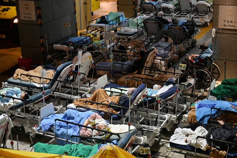 Люди лежат на больничных койках возле Медицинского центра Каритас в Гонконге Люди лежат на больничных койках возле Медицинского центра Каритас в Гонконге