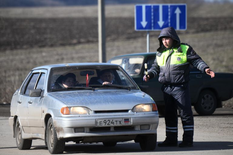 Сотрудник правоохранительных органов ДНР общается с водителем у контрольно-пропускного пункта Успенка в Донецкой области Сотрудник правоохранительных органов ДНР общается с водителем у контрольно-пропускного пункта Успенка в Донецкой области