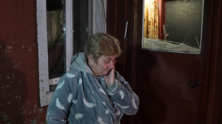 Женщина во дворе своего дома, пострадавшего в результате обстрела, в поселке шахты Трудовская в Донецке Женщина во дворе своего дома, пострадавшего в результате обстрела, в поселке шахты Трудовская в Донецке