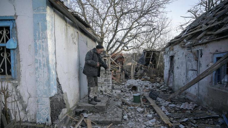 Мужчина во дворе своего дома, пострадавшего в результате обстрела в селе Тарамчук Донецкой области Мужчина во дворе своего дома, пострадавшего в результате обстрела в селе Тарамчук Донецкой области