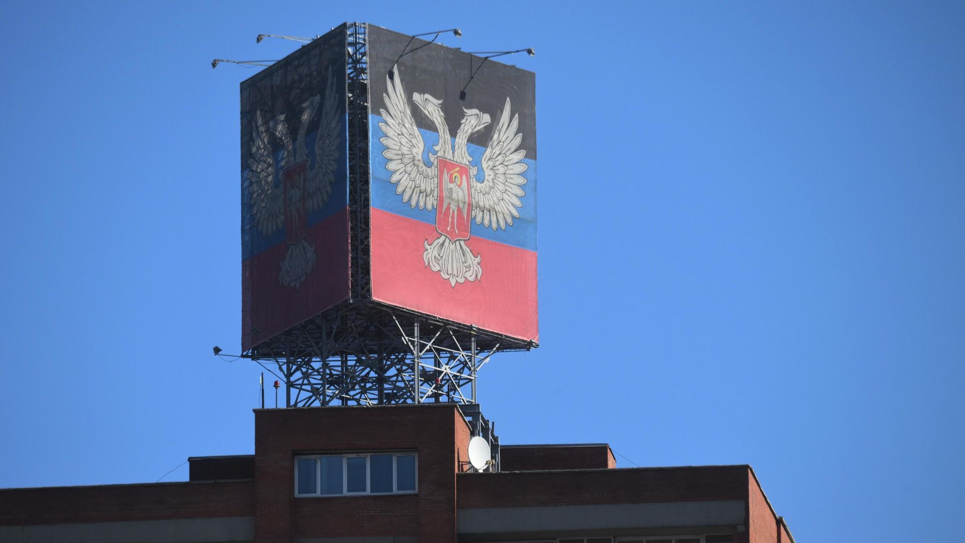 Баннер с символикой самопровозглашенной Донецкой народной республики на крыше одного из зданий в центре Донецка - РИА Новости, 1920, 22.02.2022
