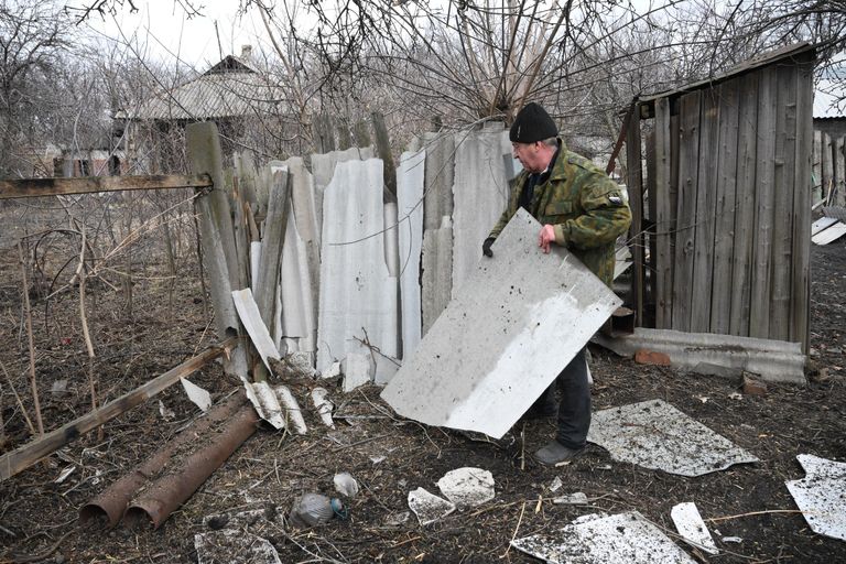Мужчина расчищает территорию возле своего дома, разрушенную в результате обстрелов в поселке Финский в Горловке Мужчина расчищает территорию возле своего дома, разрушенную в результате обстрелов в поселке Финский в Горловке