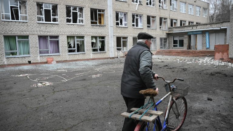 Мужчина у здания школы в Горловке, поврежденной в результате обстрела Мужчина у здания школы в Горловке, поврежденной в результате обстрела