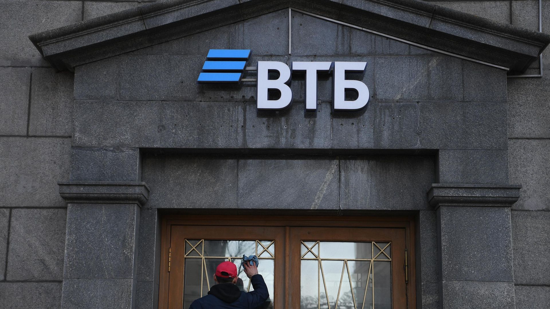 Сотрудник протирает стекла двери офиса ВТБ банка в Москве Сотрудник протирает стекла двери офиса ВТБ банка в Москве - РИА Новости, 1920, 29.08.2022