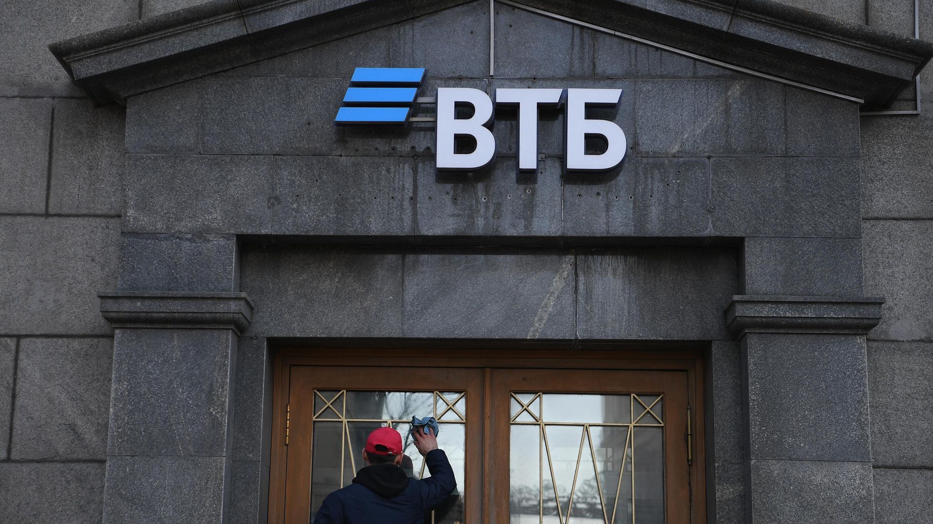Сотрудник протирает стекла двери офиса ВТБ банка в Москве Сотрудник протирает стекла двери офиса ВТБ банка в Москве - РИА Новости, 1920, 22.03.2022