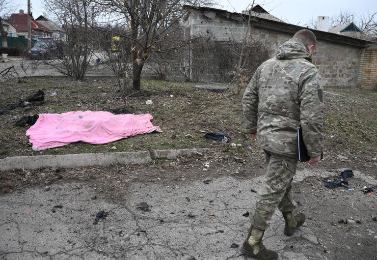 Военнослужащий у трупа сотрудника газовой службы, погибшего в результате обстрелов в Киевском районе Донецка Военнослужащий у трупа сотрудника газовой службы, погибшего в результате обстрелов в Киевском районе Донецка