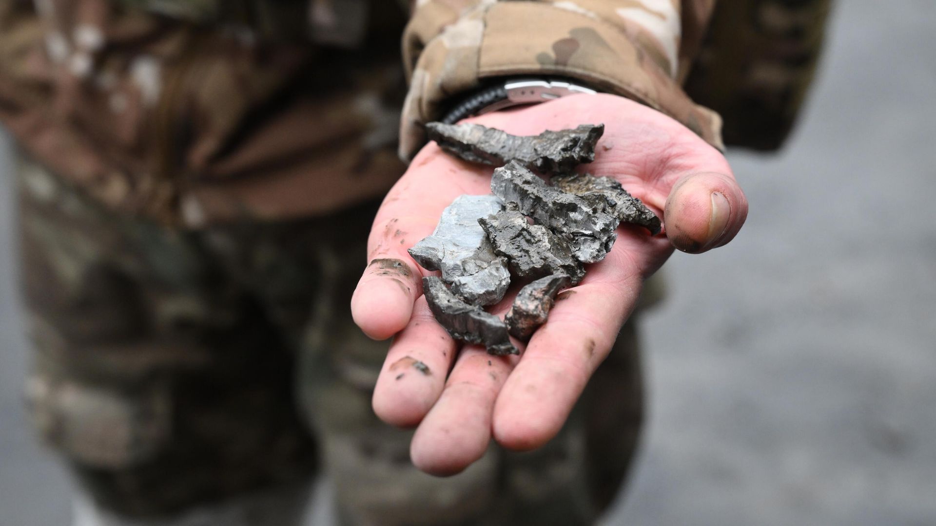 Военнослужащий демонстрирует осколки боеприпасов во дворе многоэтажного жилого дома в Донецке, поврежденного в результате обстрела Военнослужащий демонстрирует осколки боеприпасов во дворе многоэтажного жилого дома в Донецке, поврежденного в результате обстрела - РИА Новости, 1920, 23.07.2022