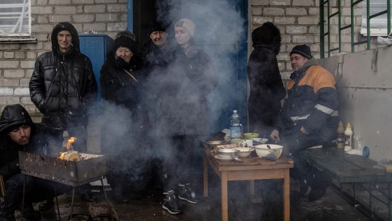 Люди готовят еду у подъезда жилого дома в освобожденном городе Счастье в Луганской народной республике Люди готовят еду у подъезда жилого дома в освобожденном городе Счастье в Луганской народной республике