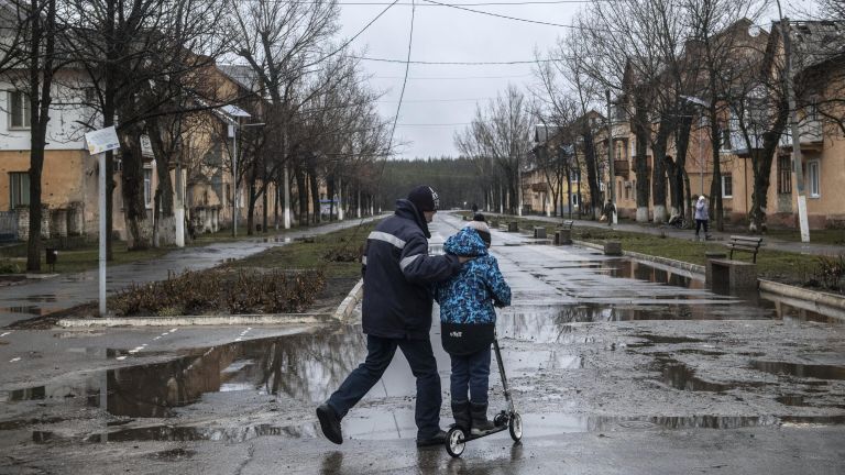 Мужчина с мальчиком на улице в освобожденном городе Счастье в Луганской народной республике Мужчина с мальчиком на улице в освобожденном городе Счастье в Луганской народной республике