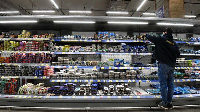 Сотрудник магазина раскладывает товар в гипермаркете Лента в Москве