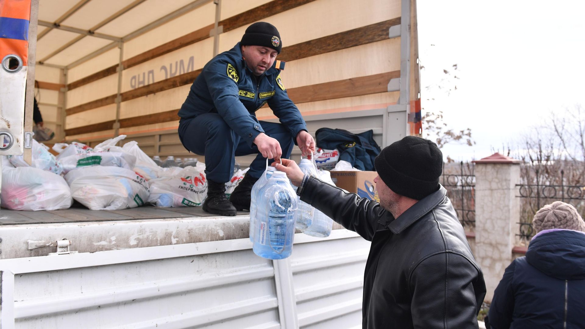 Сотрудник МЧС ДНР передает бутыли воды и продуктовый набор из гуманитарной помощи жителю села Бугас - РИА Новости, 1920, 12.03.2022