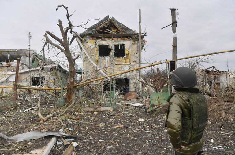 Мужчина фотографирует один из разрушенных домов села Сопино в Донецкой народной республике Мужчина фотографирует один из разрушенных домов села Сопино в Донецкой народной республике