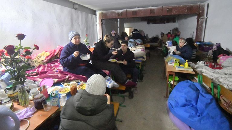 Местные жители, живущие в бомбоубежище в подвале специализированной школы с углубленным изучением новогреческого языка в поселке Сартана в Донецкой народной республике