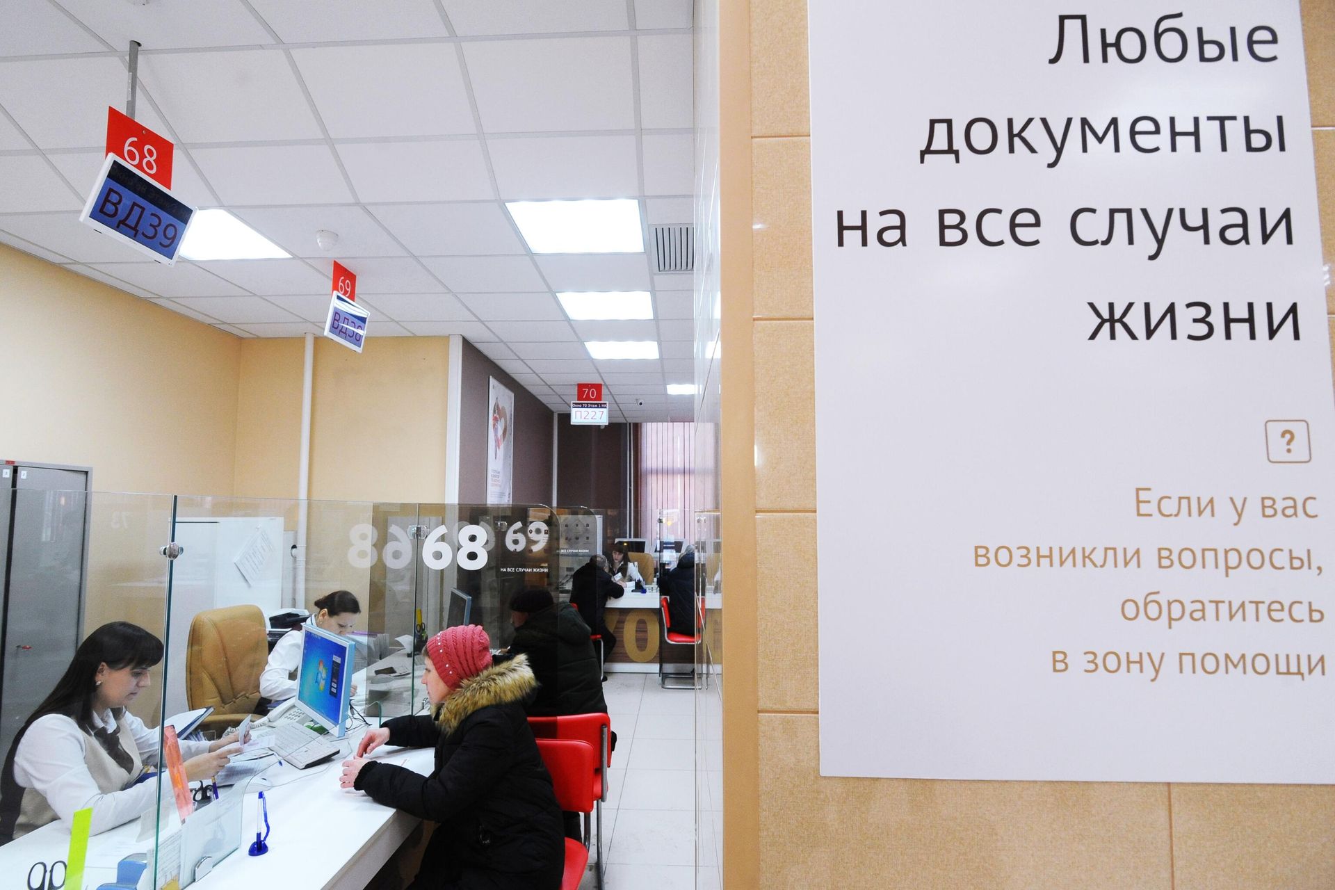 Специалисты МФЦ консультируют посетителей филиала в зоне обслуживания - РИА Новости, 1920, 06.03.2025