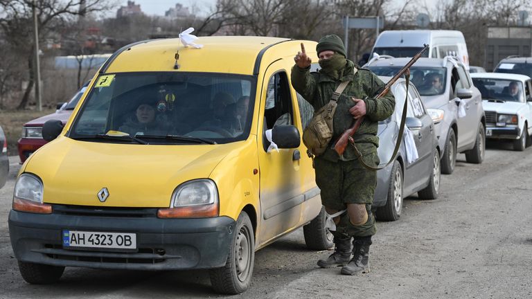 Военнослужащий НА ДНР указывает дорогу беженцам на автомобиле покидающим Мариуполь Военнослужащий НА ДНР указывает дорогу беженцам на автомобиле покидающим Мариуполь