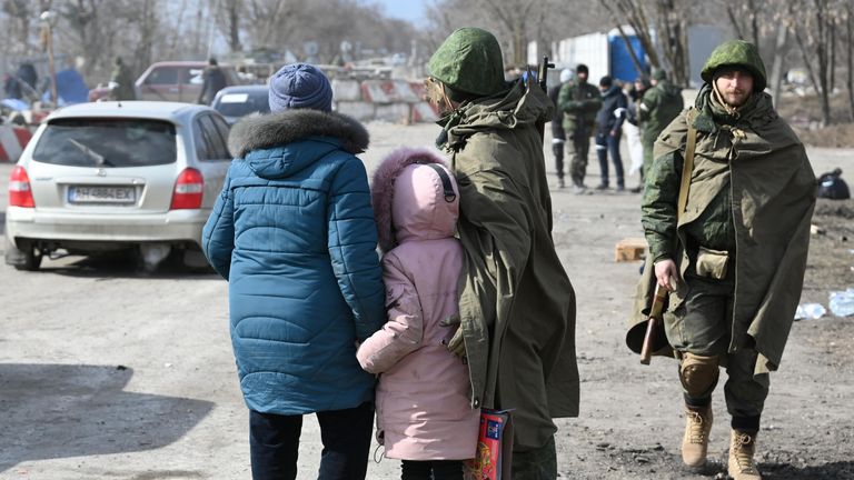 Военнослужащий НА ДНР общается с беженцами на выезде из Мариуполя Военнослужащий НА ДНР общается с беженцами на выезде из Мариуполя