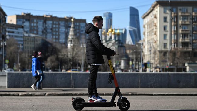 Молодой человек едет на электросамокате