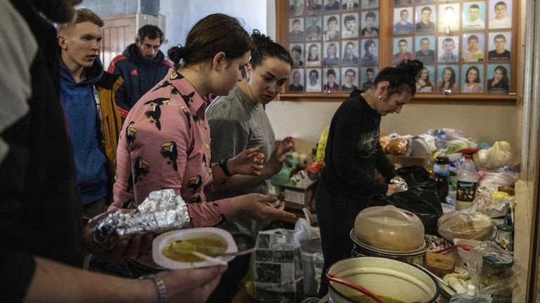 Люди разбирают продукты в центре размещения беженцев, расположенном в здании детско-юношеской спортивной школы в Старобельске