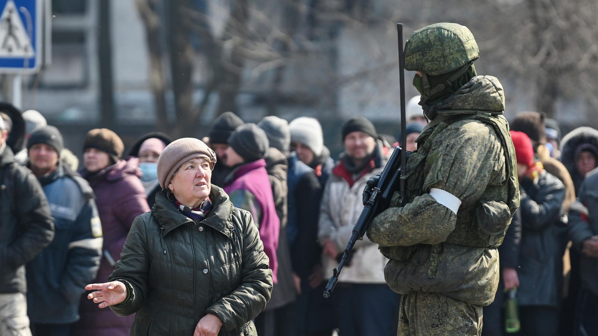 Женщина из очереди, где люди ожидают выдачу гуманитарной помощи, разговаривает с военнослужащим - РИА Новости, 1920, 25.03.2022