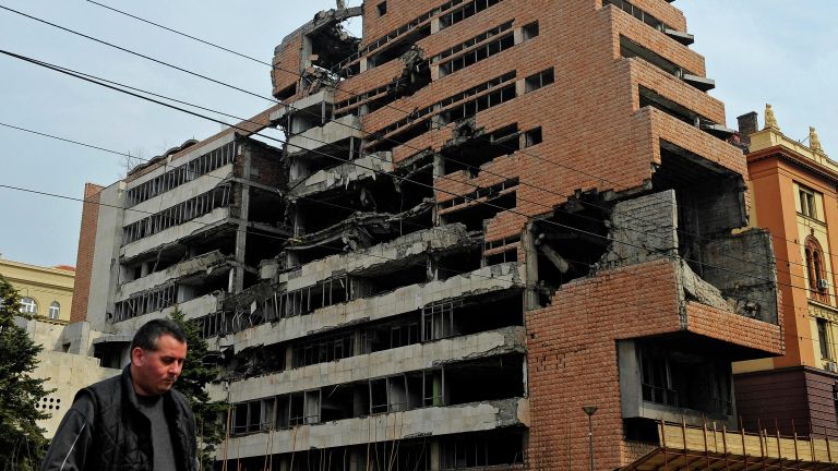 Мужчина проходит мимо здания бывшего федерального военного штаба в Белграде, разрушенного во время воздушной кампании НАТО. 24 марта 2010 года Мужчина проходит мимо здания бывшего федерального военного штаба в Белграде, разрушенного во время воздушной кампании НАТО. 24 марта 2010 года