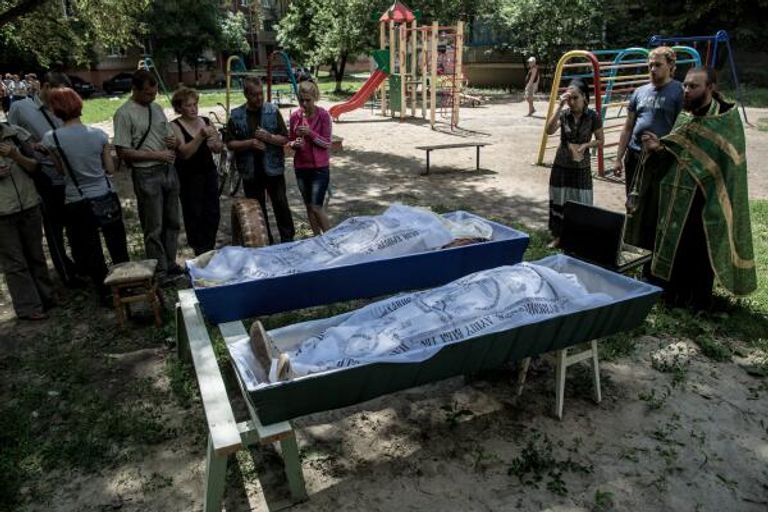 Отпевание погибших во дворе жилого дома. Последствия артиллерийского обстрела украинскими военными микрорайона Артема в Славянске. Отпевание погибших во дворе жилого дома. Последствия артиллерийского обстрела украинскими военными микрорайона Артема в Славянске.