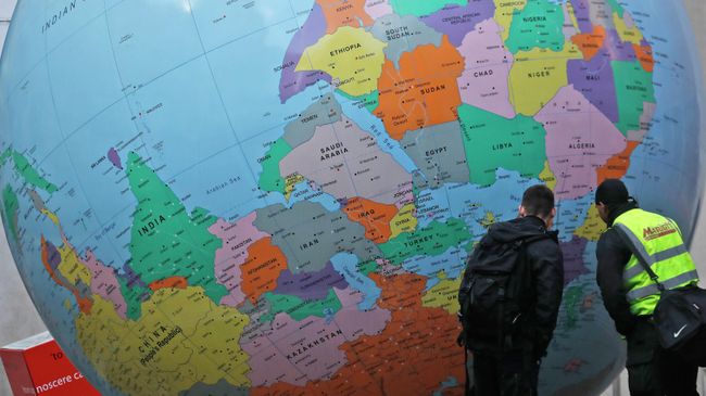 Мужчины рассматривают глобус, установленный у Лондонской школы экономики 