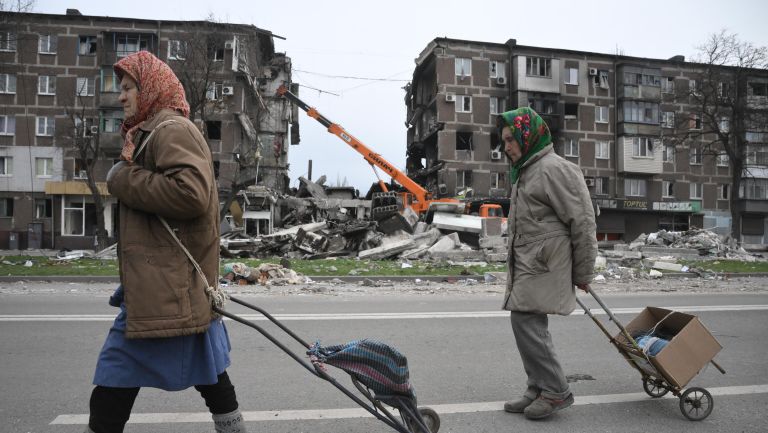 Жители Мариуполя идут по улице города Жители Мариуполя идут по улице города