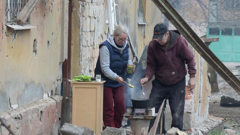 Жители Левобережного района Мариуполя готовят еду на костре возле подъезда дома Жители Левобережного района Мариуполя готовят еду на костре возле подъезда дома