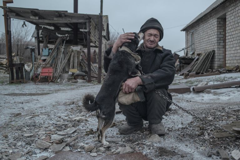 62-летний Александр Васильев со своей собакой - один из последних жителей поселка Новомарьевка Донецкой области. 62-летний Александр Васильев со своей собакой - один из последних жителей поселка Новомарьевка Донецкой области.