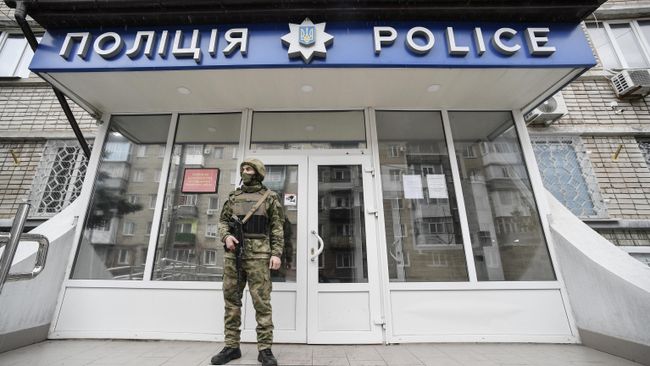 Военнослужащий у входа в здание полиции Военнослужащий у входа в здание полиции