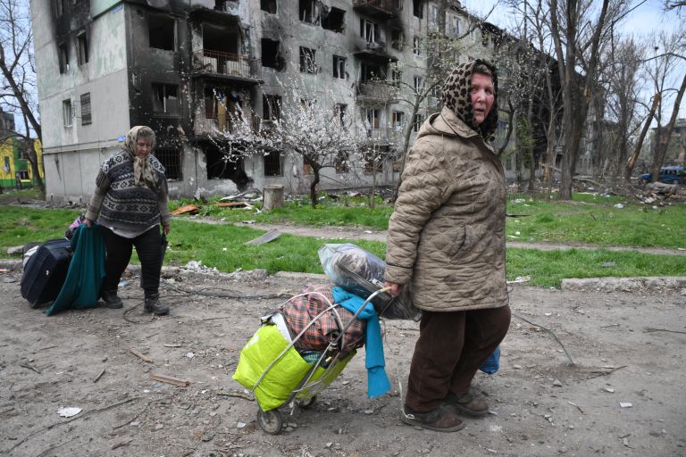 Жители идут по улице в Левобережном районе Мариуполя Жители идут по улице в Левобережном районе Мариуполя