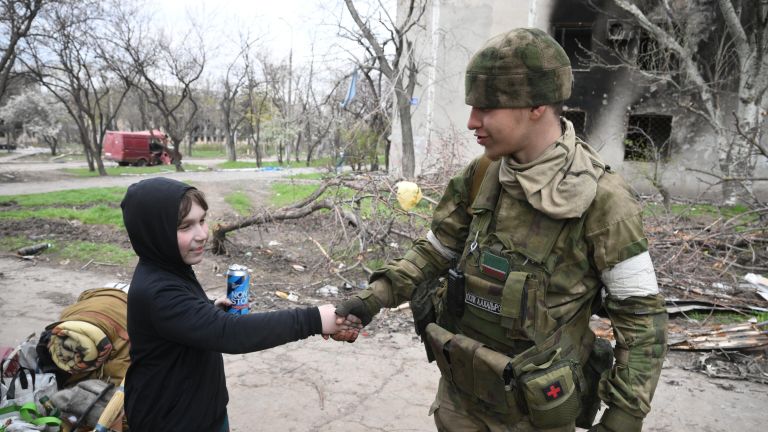 Мальчик пожимает руку бойцу полка полиции специального назначения имени Героя России А. А. Кадырова МВД по Чеченской Республике в Левобережном районе Мариуполя