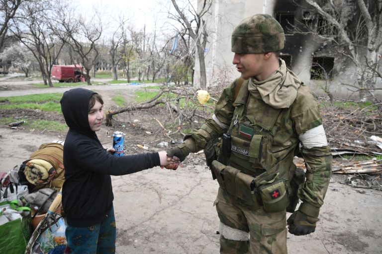 Мальчик пожимает руку бойцу полка полиции специального назначения имени Героя России А. А. Кадырова МВД по Чеченской Республике в Левобережном районе Мариуполя Мальчик пожимает руку бойцу полка полиции специального назначения имени Героя России А. А. Кадырова МВД по Чеченской Республике в Левобережном районе Мариуполя