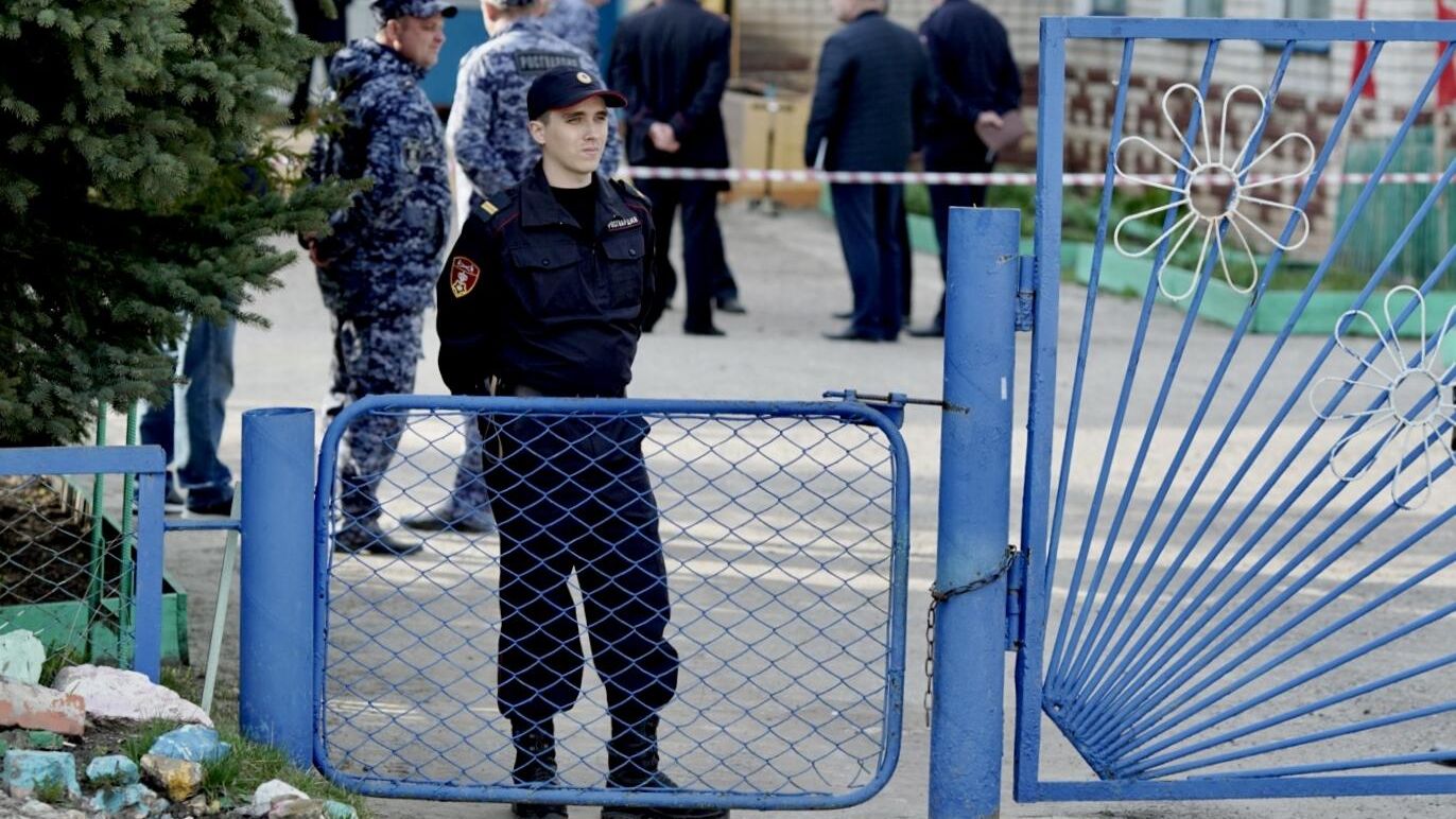 Сотрудник Росгвардии у детского сада Рябинка в поселке Вешкайма, где произошла стрельба Сотрудник Росгвардии у детского сада Рябинка в поселке Вешкайма, где произошла стрельба - РИА Новости, 1920, 26.04.2022