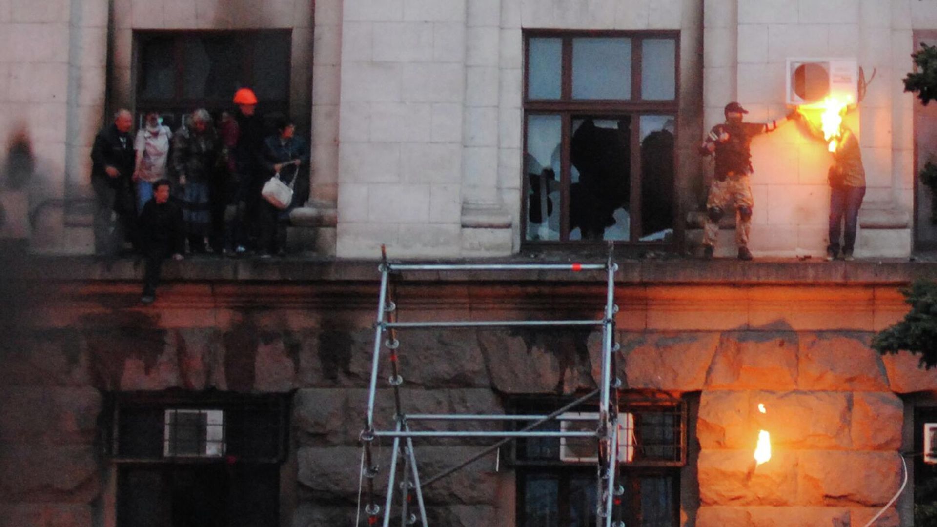 Люди выбрались на карниз во время пожара в Доме профсоюзов в Одессе. Справа: на лицо и волосы девушки попал тряпичный кляп с горючей смесью от брошенной бутылки коктейля Молотова. Люди выбрались на карниз во время пожара в Доме профсоюзов в Одессе. Справа: на лицо и волосы девушки попал тряпичный кляп с горючей смесью от брошенной бутылки коктейля Молотова. - РИА Новости, 1920, 02.05.2026