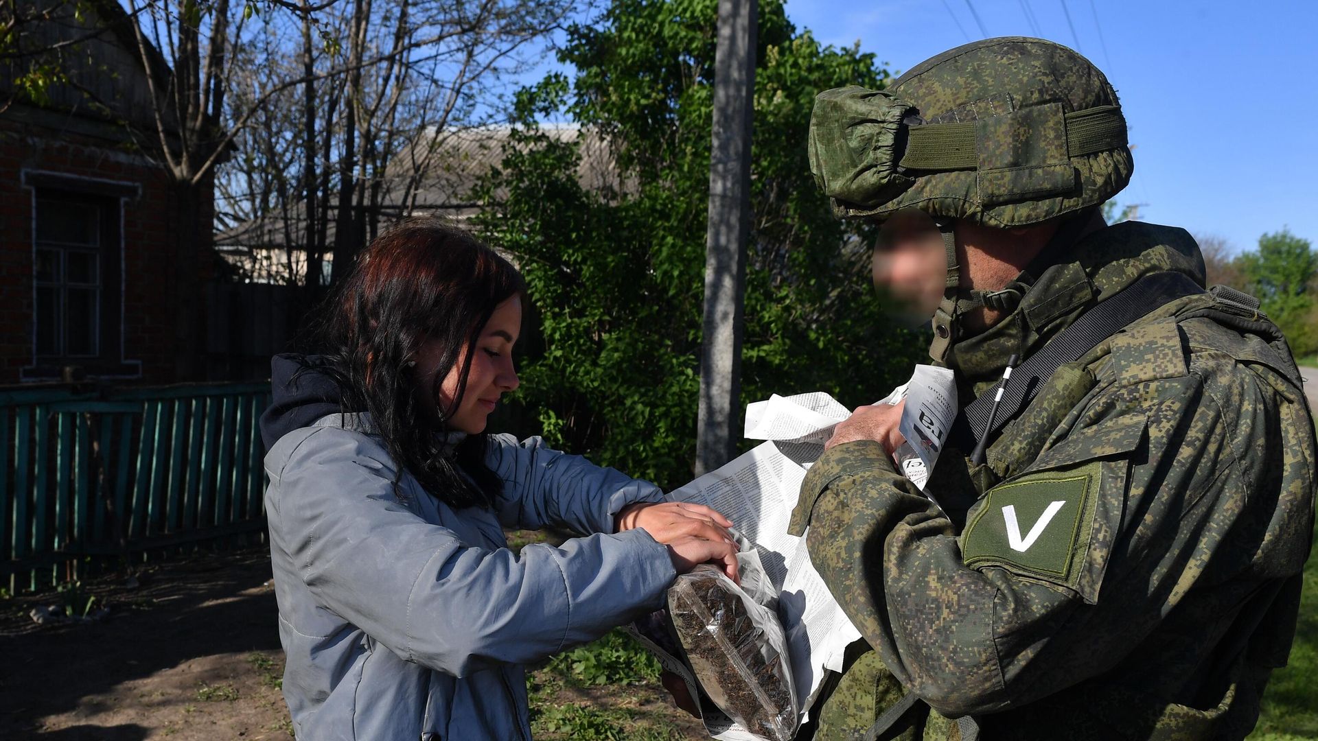 Военнослужащий ВС РФ раздает российскую гуманитарную помощь жителям одного из сел в Харьковской области - РИА Новости, 1920, 19.05.2022