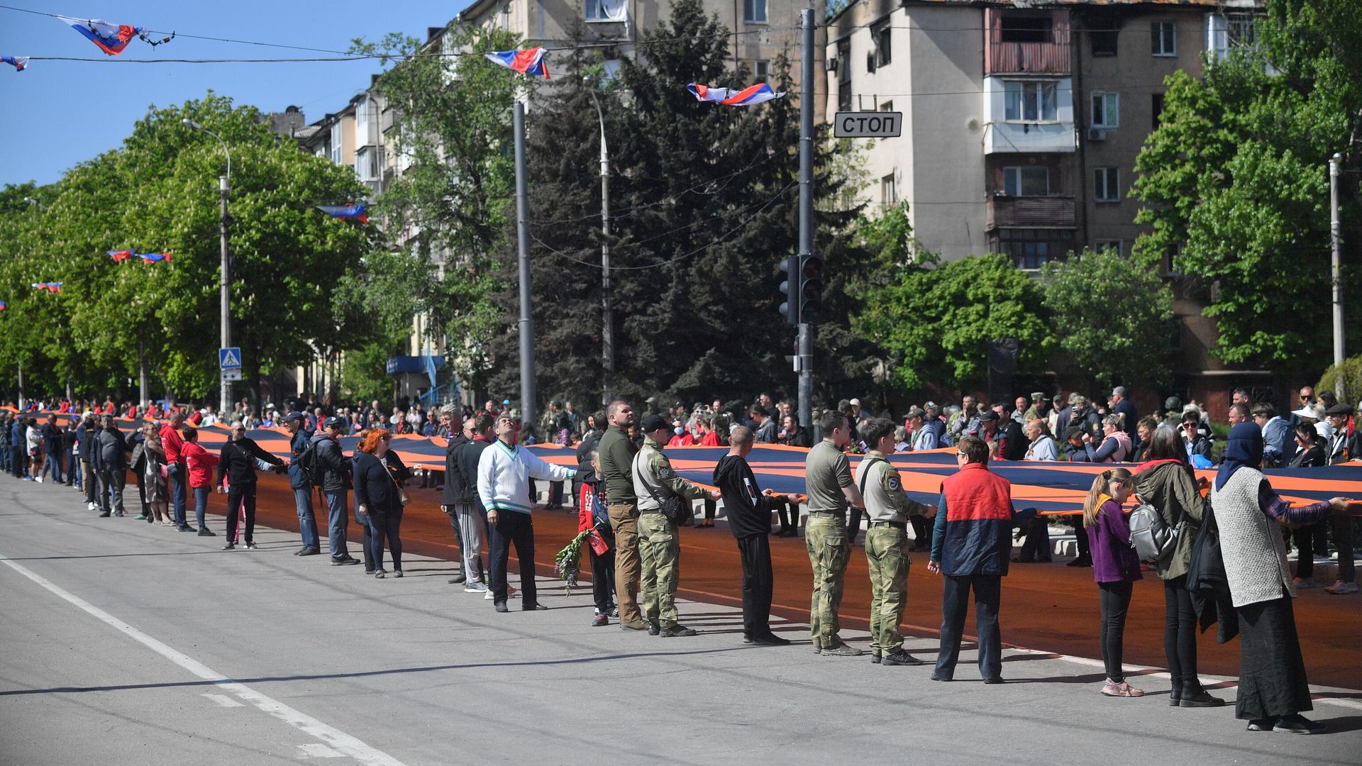 Колонна людей во время шествия с 300-метровой георгиевской лентой в Мариуполе на праздничных мероприятиях Колонна людей во время шествия с 300-метровой георгиевской лентой в Мариуполе на праздничных мероприятиях - РИА Новости, 1920, 05.08.2026