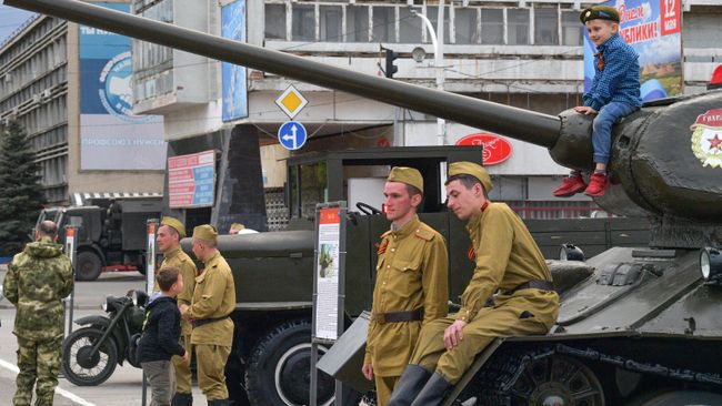 Мальчик сидит на танке на выставке военной техники во время празднования Дня Победы в Луганске Мальчик сидит на танке на выставке военной техники во время празднования Дня Победы в Луганске