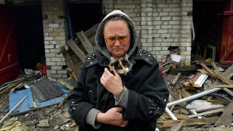 Женщина с кошкой в разрушенном частном секторе города Попасная Женщина с кошкой в разрушенном частном секторе города Попасная