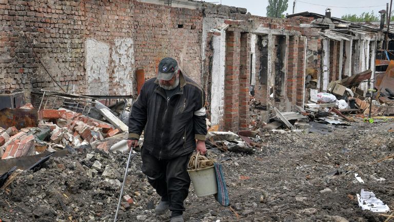 Мужчина идет мимо разрушенных построек в частном секторе города Попасная Мужчина идет мимо разрушенных построек в частном секторе города Попасная