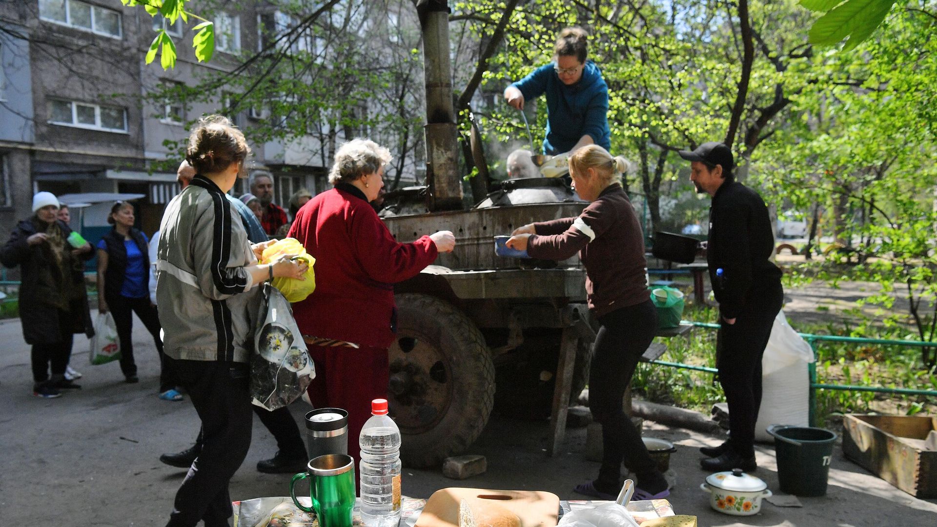 Жители готовят еду в полевой кухне во дворе разрушенного дома в Левобережном районе Мариуполя Жители готовят еду в полевой кухне во дворе разрушенного дома в Левобережном районе Мариуполя - РИА Новости, 1920, 20.05.2022