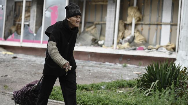 Женщина на одной из улиц в Мариуполе