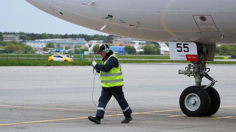 Техник возле авиалайнера МС-21-310 с двигателем ПД-14 на взлетно-посадочной полосе перед началом испытаний самолета в Жуковском Техник возле авиалайнера МС-21-310 с двигателем ПД-14 на взлетно-посадочной полосе перед началом испытаний самолета в Жуковском