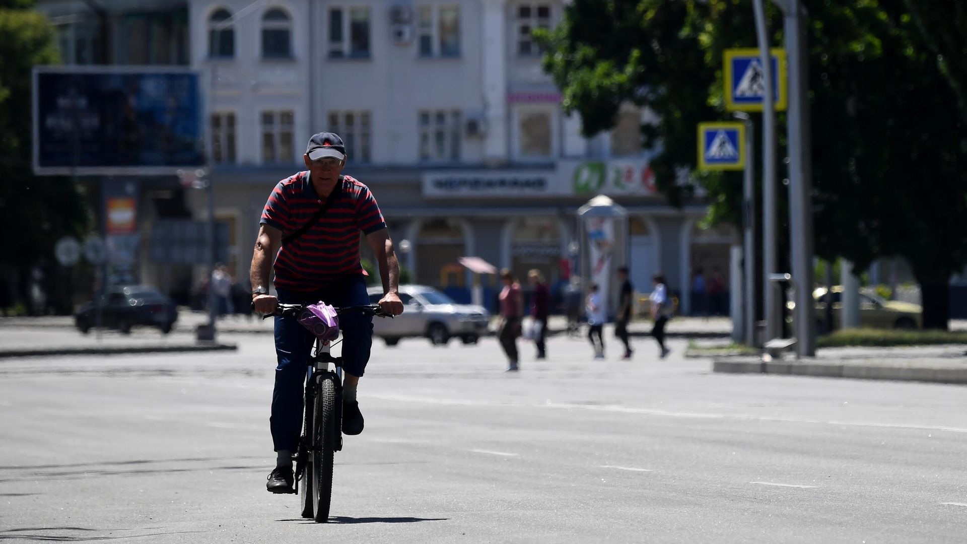 Мужчина едет на велосипеде по одной из улиц в Мелитополе Мужчина едет на велосипеде по одной из улиц в Мелитополе - РИА Новости, 1920, 30.05.2022