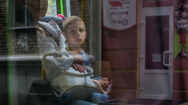 Мальчик в автобусе. Жители Славянска, который подвергается обстрелам украинскими силовиками, эвакуируют детей из города. Мальчик в автобусе. Жители Славянска, который подвергается обстрелам украинскими силовиками, эвакуируют детей из города.