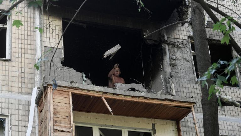 Мужчина выбрасывает разбитое стекло с балкона поврежденного жилого дома в Петровском районе Донецка после обстрелов украинскими войсками Мужчина выбрасывает разбитое стекло с балкона поврежденного жилого дома в Петровском районе Донецка после обстрелов украинскими войсками